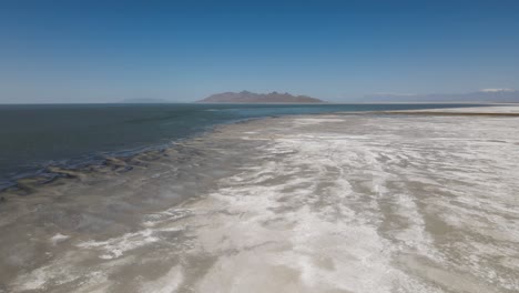 Eine-4K-Drohne-Schoss-über-Die-Vollkommen-Flache-Bonneville-Salzebene-Westlich-Des-Great-Salt-Lake-Im-Westen-Utahs,-Wo-Eine-Flache-Schicht-Stehenden-Wassers-Die-Oberfläche-Der-Riesigen-Salzebene-überschwemmt