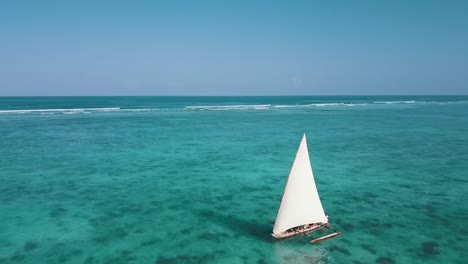 1-Million-$-Flug-über-Ein-Segelboot-Mit-Weißen-Segeln-Vor-Der-Küste-Von-Kristallklarem-Türkisfarbenem-Wasser