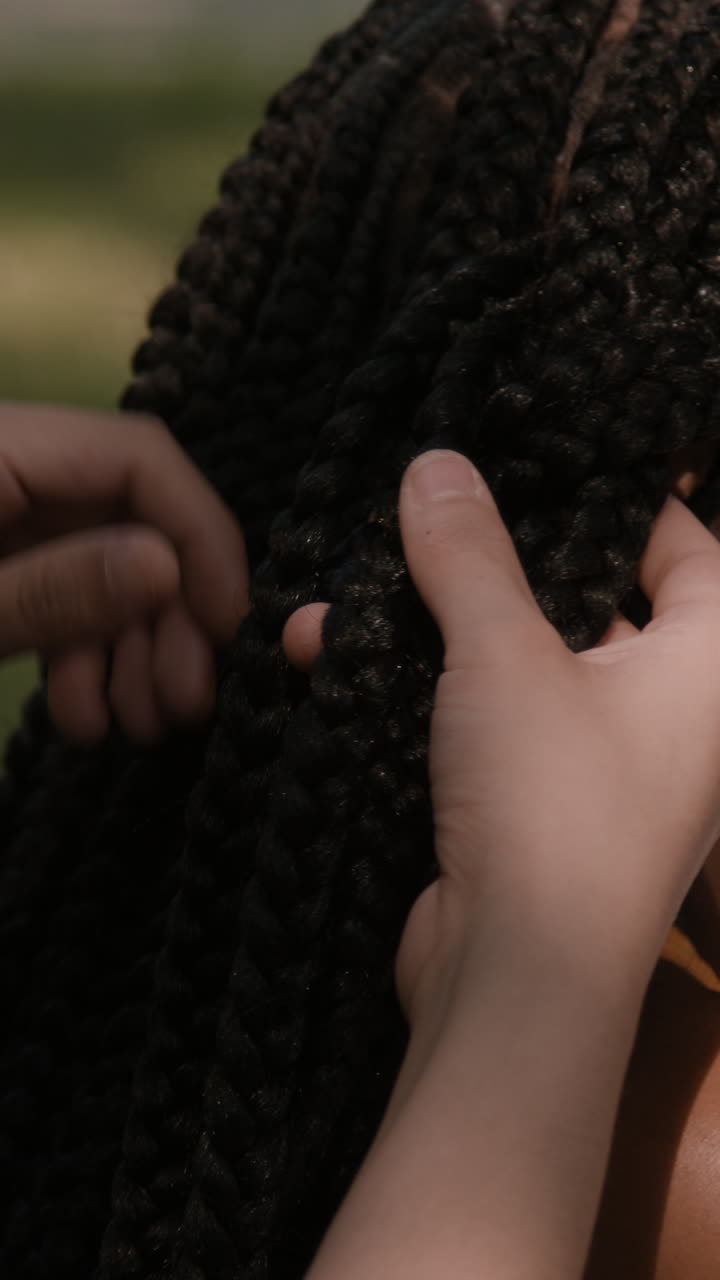 Hands braiding hair