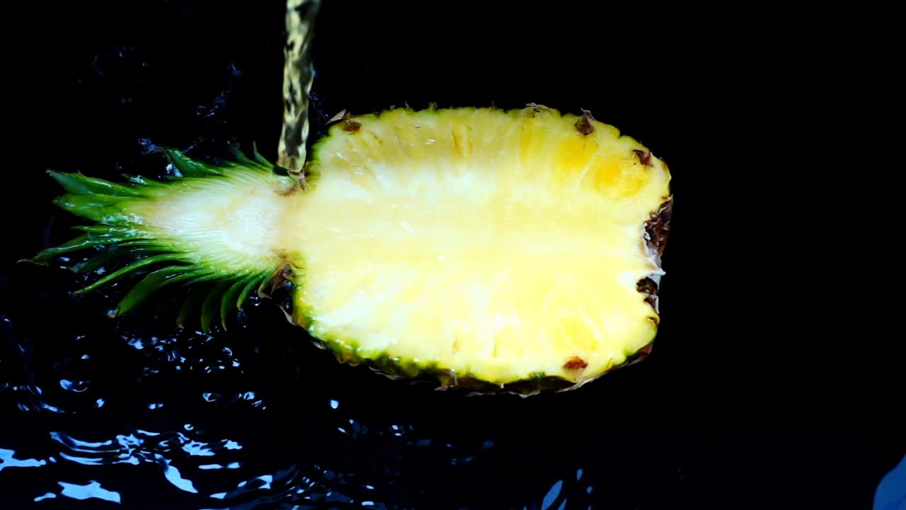 The stream of water flows on pineapple. Slow motion