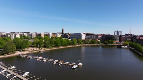 drone rises from dock harbor in helsinki finland to reveal grand cityscape on summer day