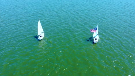 Aerial-view-of-sailboats-with-American-flag-at-Wallenpaupack-lake,-Pennsylvania,-USA