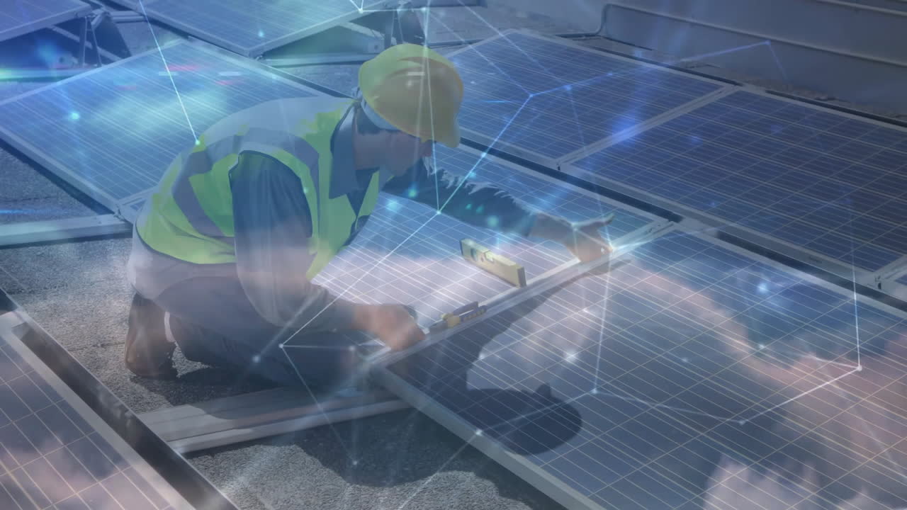 male technician kneeling aligning solar panel on rooftop, showing network overlay for energy tech