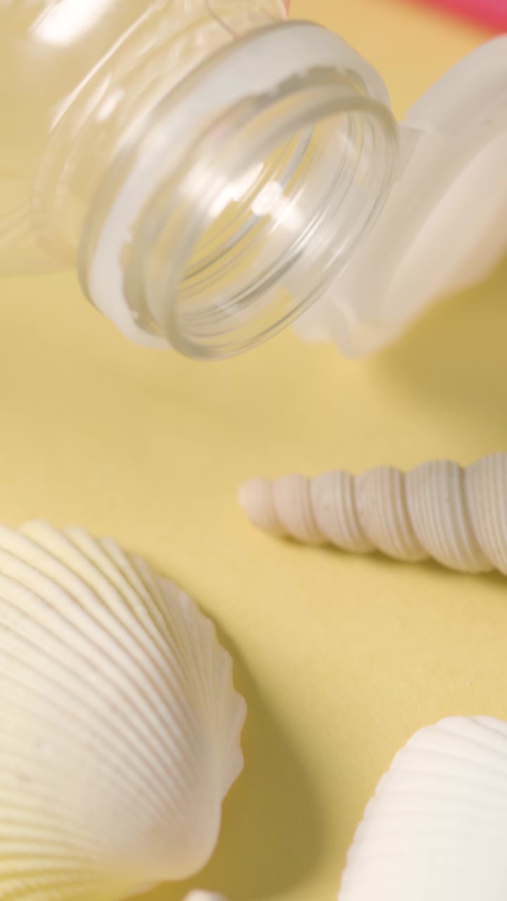 플라스틱 병, 쓰레기 데기, 해변에서 회전하는 바다별의 수직 비디오 오염 개념