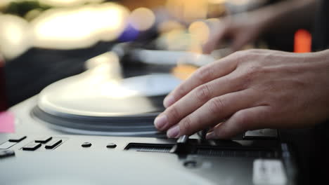 dj fast-forwards track on turntable to mix music at outdoor event party