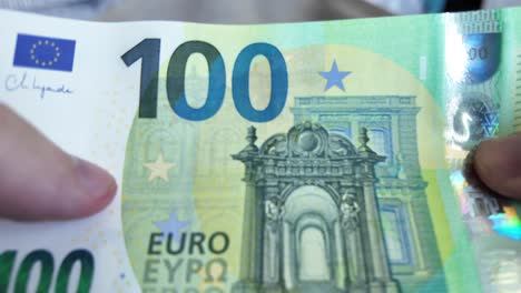 in slow motion video, a man holds and counts euro banknotes