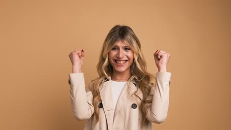 enthusiastic transgender woman with clenched fists celebrating victory