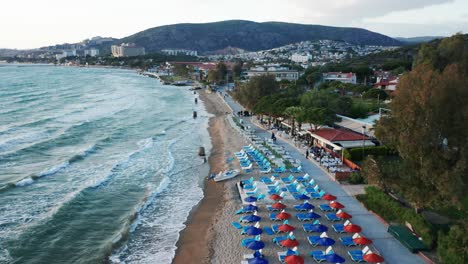 Resort-on-sandy-beach-with-umbrellas-at-popular-travel-destination-Kusadasi,-Turkey---drone