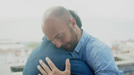 Plano-Medio-De-Una-Pareja-Gay-Abrazándose-Y-Luego,-Uno-De-Ellos-Mira-A-La-Cámara