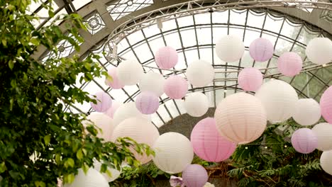 white pink balls of rice paper hanging on the branches of green trees