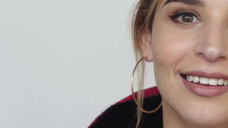 Retrato-De-Una-Hermosa-Mujer-Elegante-Con-Media-Cara-Sonriendo-Feliz-Usando-Aretes-Cosméticos-De-Maquillaje-Sobre-Fondo-Blanco