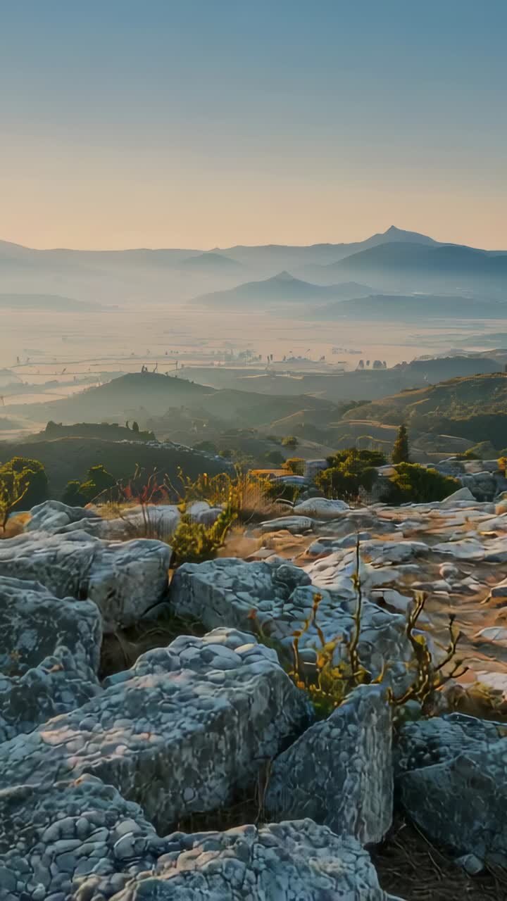 Video verticale: carrellata che rivela rocce calcaree chiare sulla cima di una collina, mostrando la vetta di una valle nebbiosa