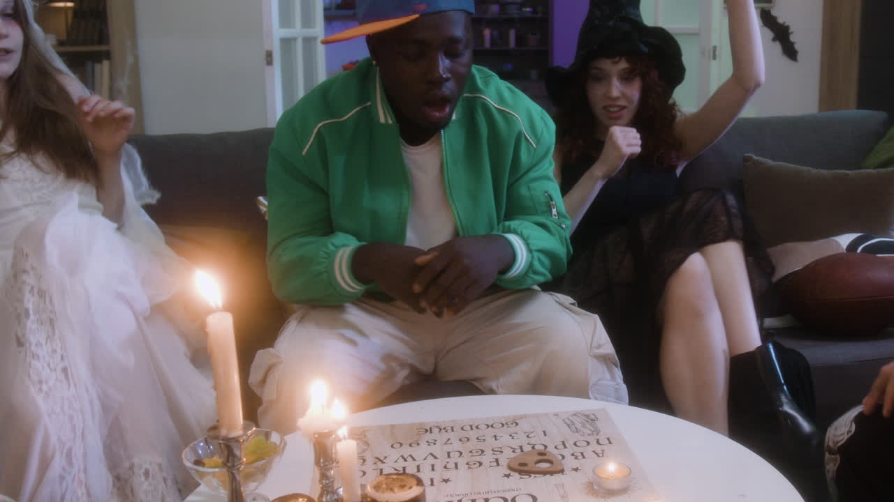 Group of People at a Halloween Party Using an Ouija Board