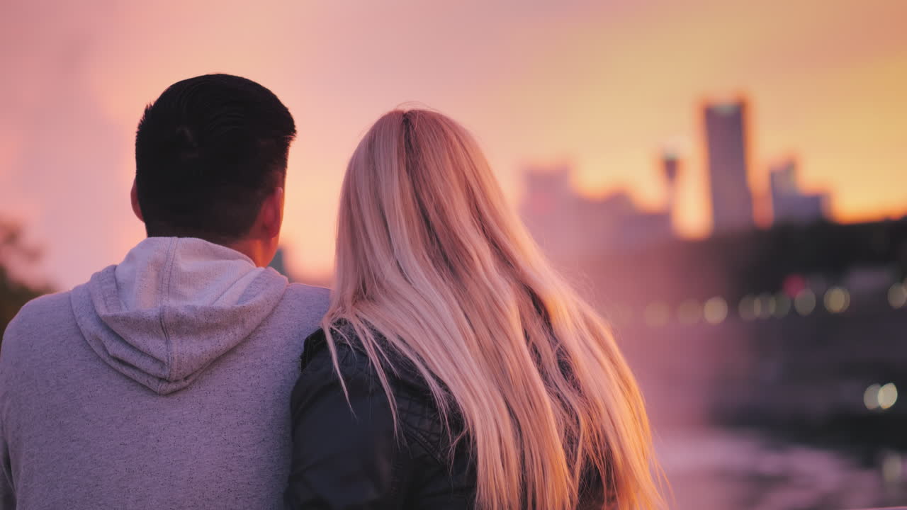 아름다운 일몰을 즐기는 유명한 나이아가라 폭포를 바라보는 다민족 커플