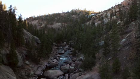 Aerial-drone-cinematic-Colorado-down-the-river-fisherman-paradise-Deckers-Cheesman-Canyon-Evergreen-Conifer-Boulder-shaded-mountainside-forest-peaceful-water-boulder-rocks-backwards-movement-flight-4k