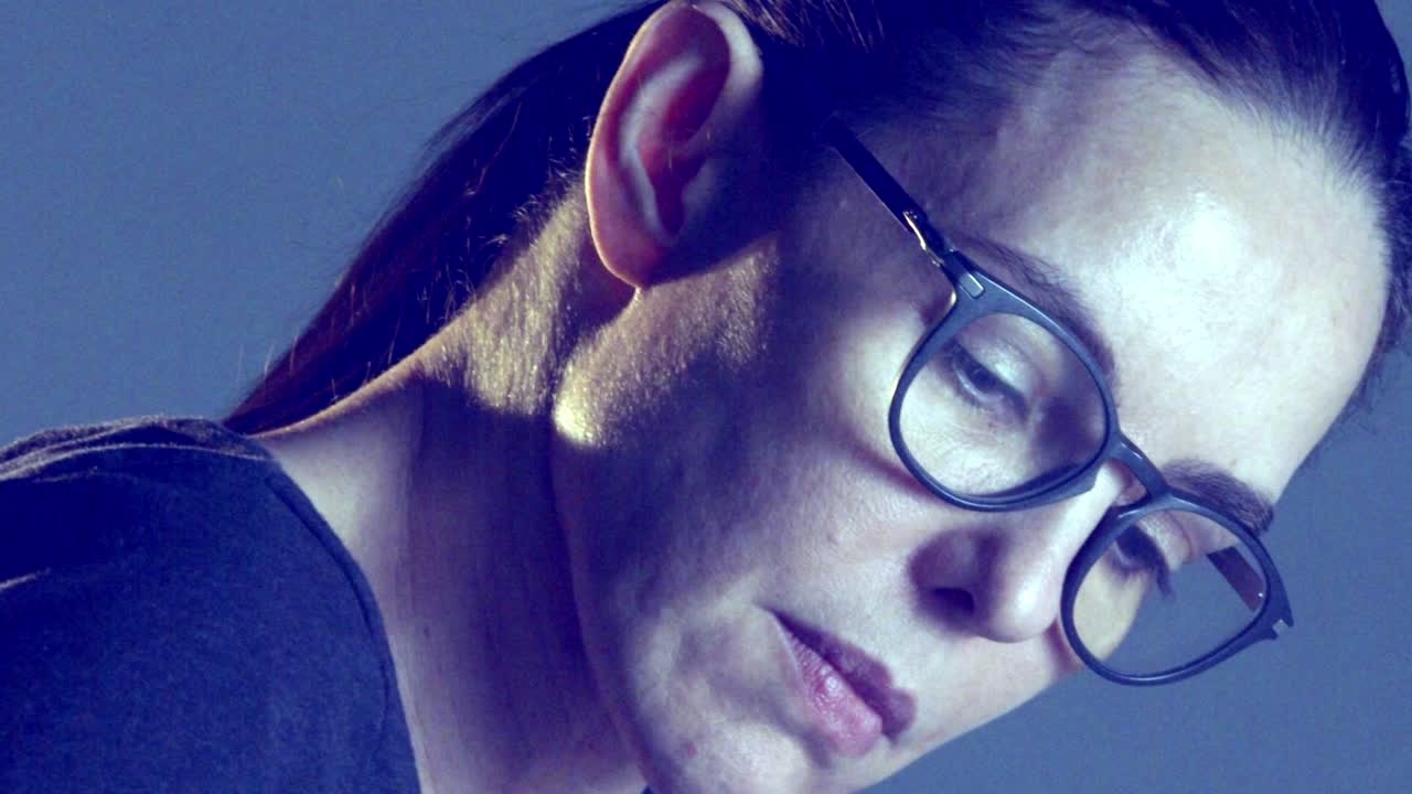 immagine ravvicinata al rallentatore del volto di una donna che indossa gli occhiali durante il suo lavoro d'ufficio