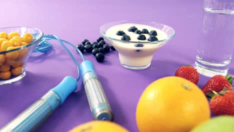 pesas, plátano, vaso de agua, fruta, cuerda para saltar y desayuno