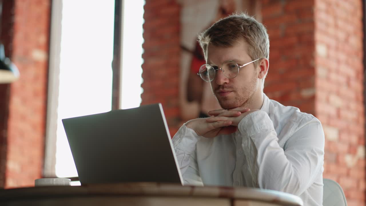 el abogado está examinando el acuerdo en la computadora portátil, mirando la pantalla y la lectura concentrada, trabajando con el cuaderno en la cafetería