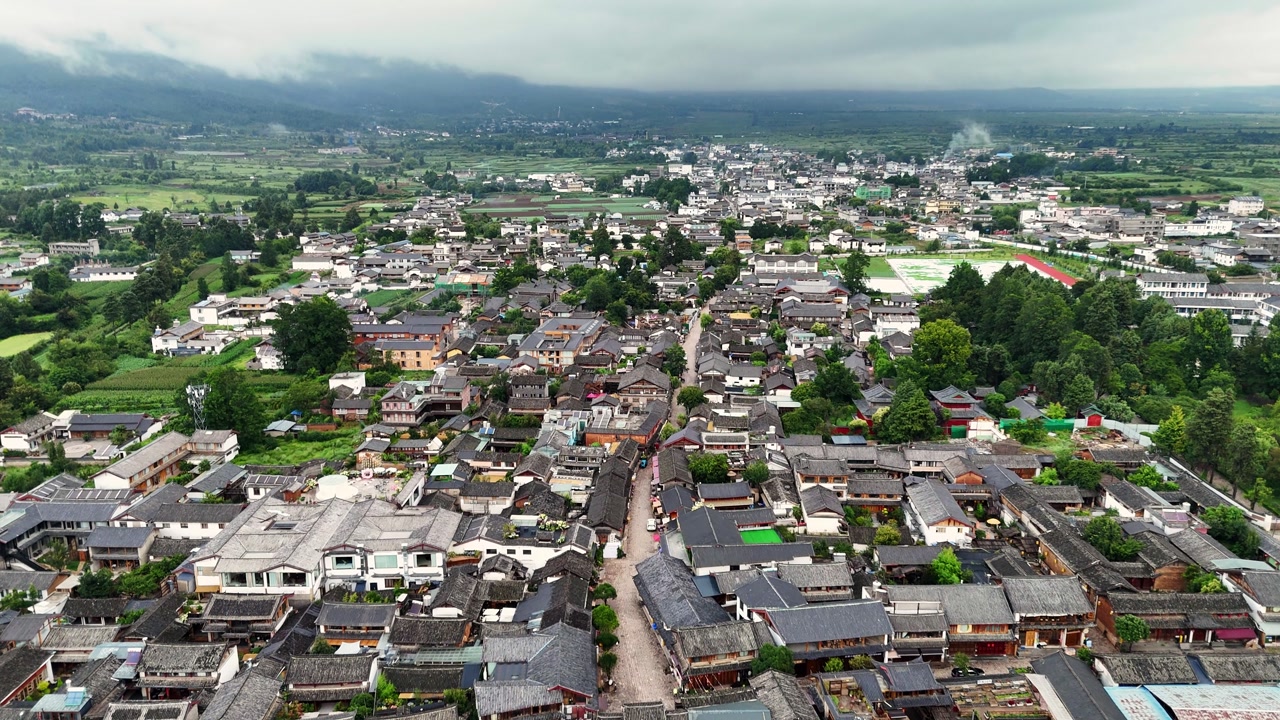 Baisha town traditional rooftops and narrow street pattern near Fuguo Monastery Yunnan, aerial tilt up backdrop