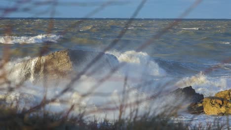 Big-stormy-waves-breaking-against-abandoned-seaside-fortification-building-at-Karosta-Northern-Forts-in-Liepaja,-slow-motion-medium-shot
