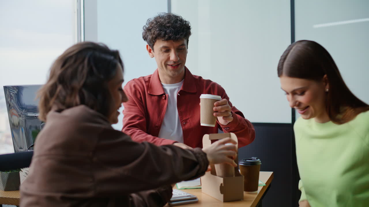 Primo piano di una donna concentrata che guarda lo schermo del computer. Colleghi sorridenti che prendono un caffè
