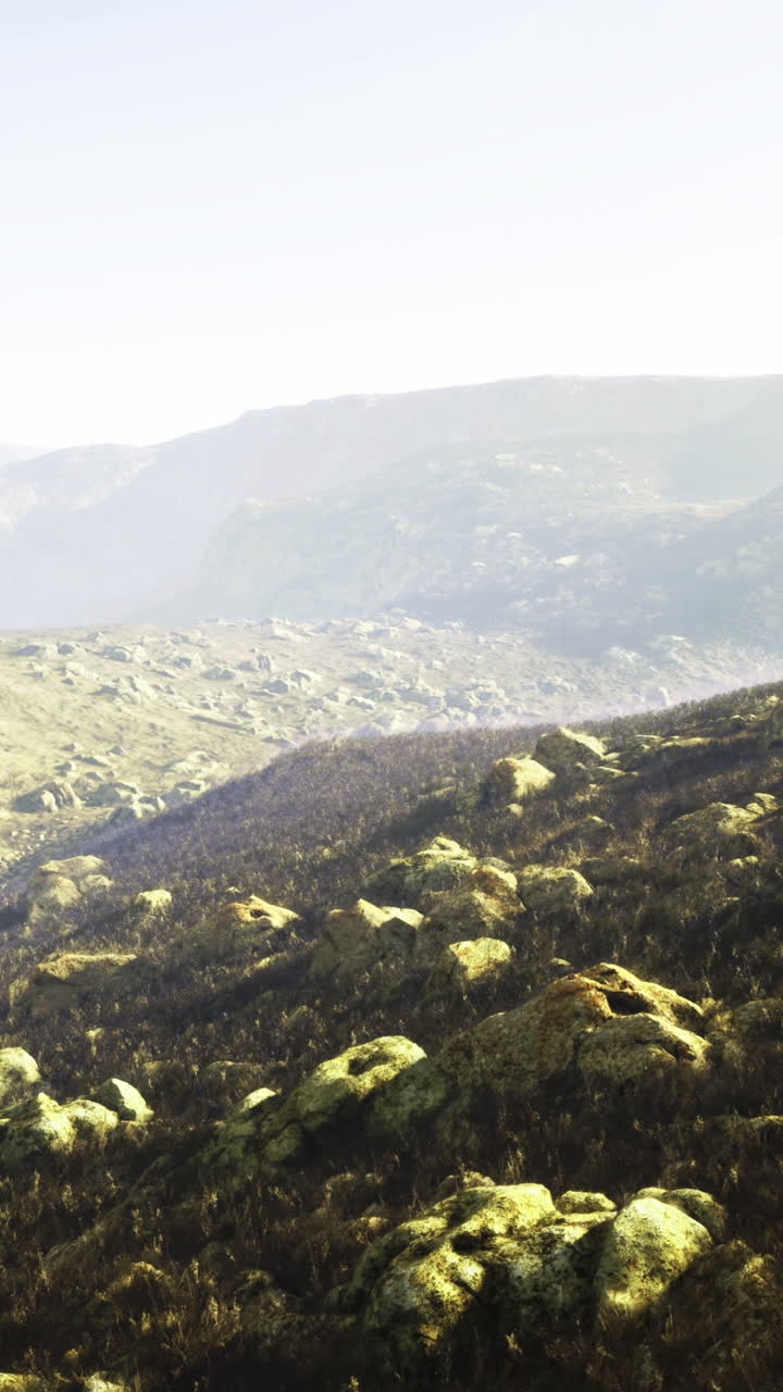 Rugged landscape with rocky terrain and distant mountain views at sunrise