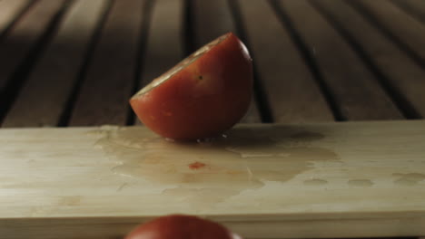 slow-mo of tomato being sliced in chopping board