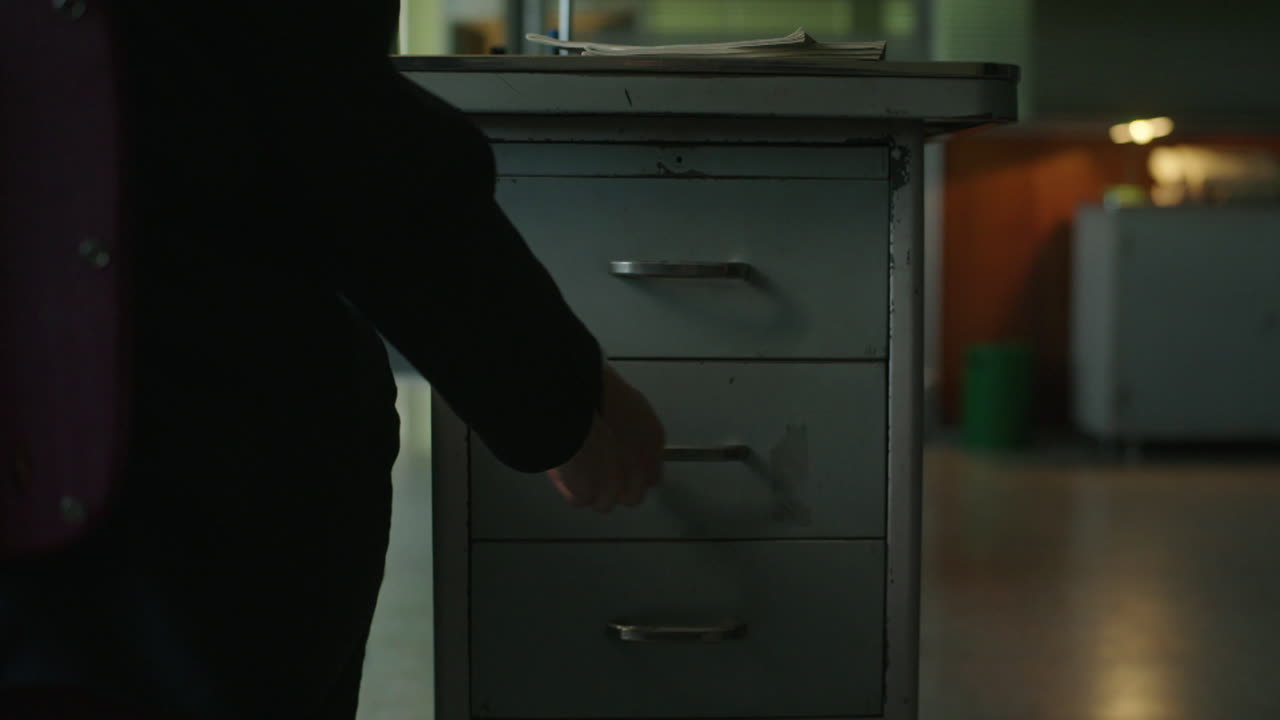 Person opening a drawer in an office