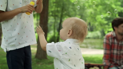Toddler-playing-with-soap-bubbles-outdoors.-Children-spending-time-with-parents