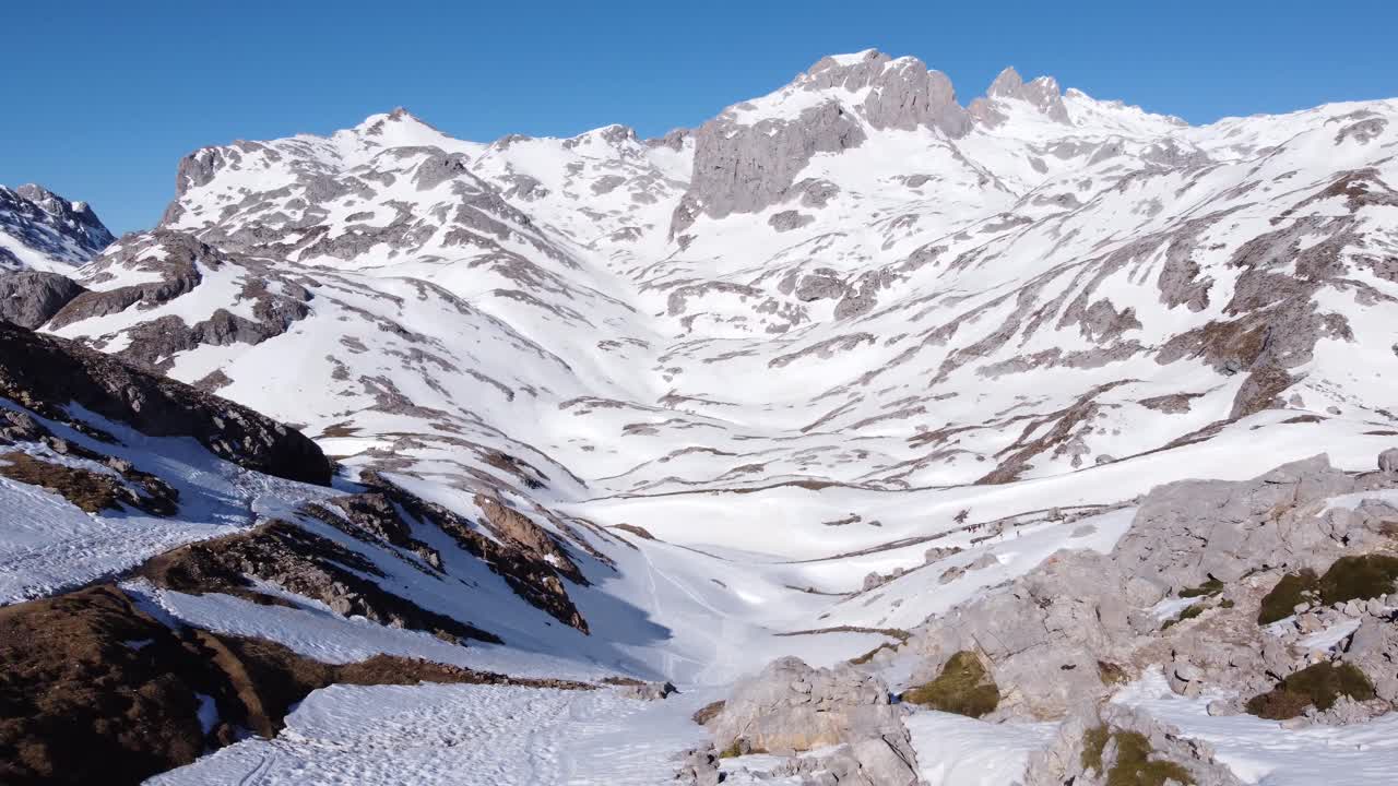 눈으로 덮인 피코스 데 에우로파 산맥을 걷고 있는 익명의 여행자