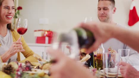 caucasian family drinking wine while sitting by dining table