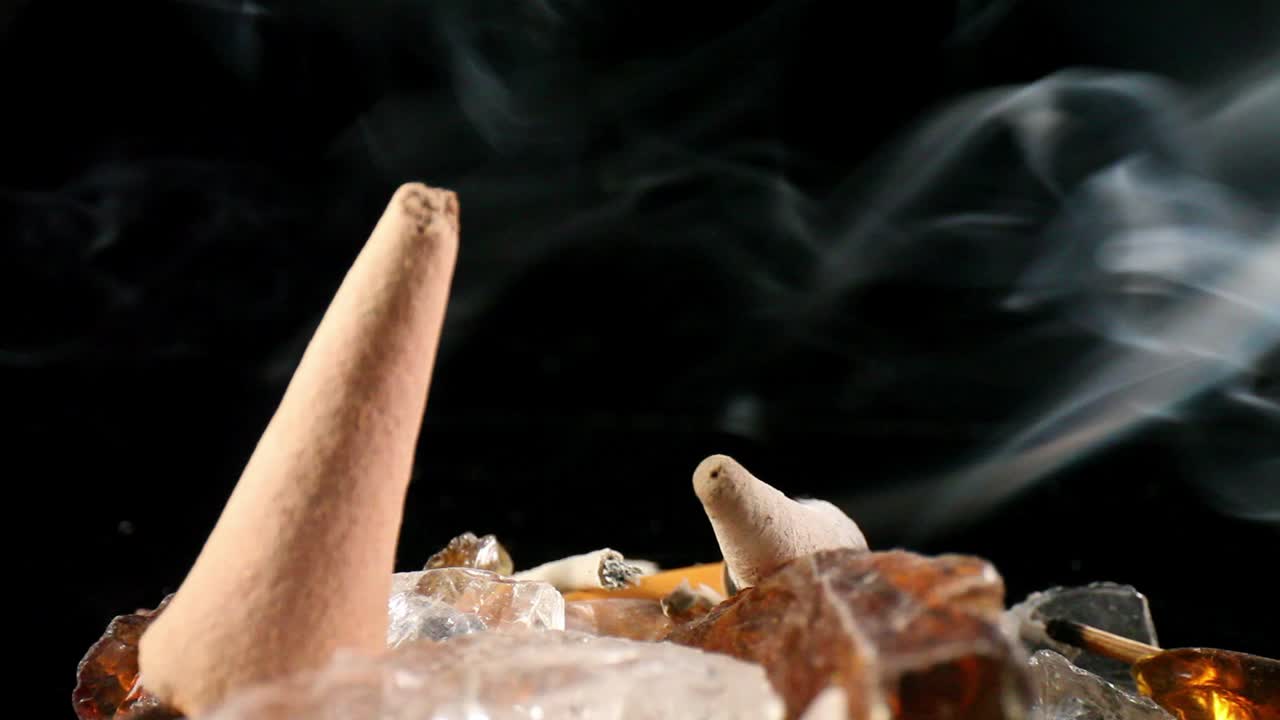 tiro estático de incienso de cono donde el humo se eleva entre las rocas: un cono apagado