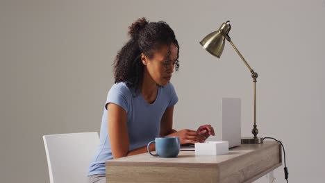 Video-of-biracial-woman-working-on-laptop-with-back-ache