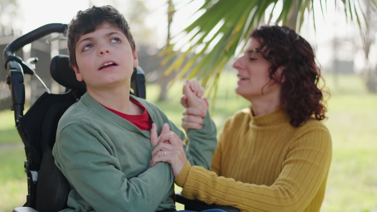 A woman and child in a wheelchair in a park