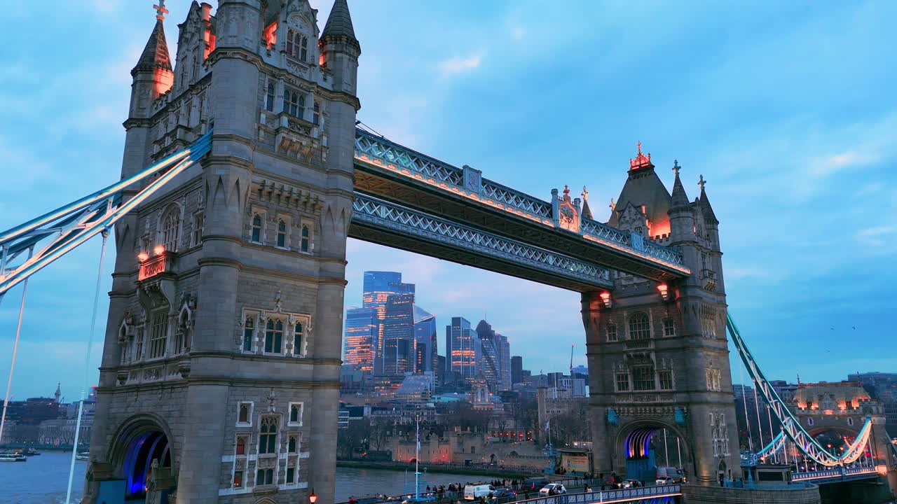 London’s bridge stands proud at night, with people and traffic in motion
