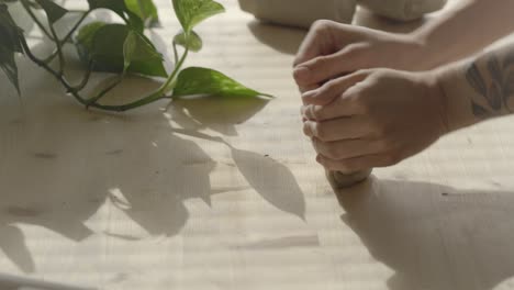 a female pottery wedging clay on a wooden table