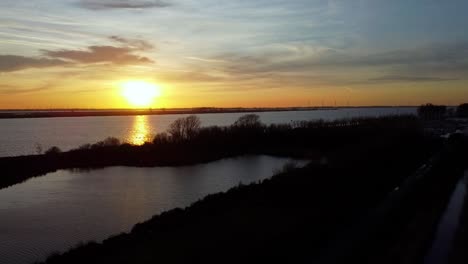 toma de drones retroiluminados de la puesta de sol en un río.