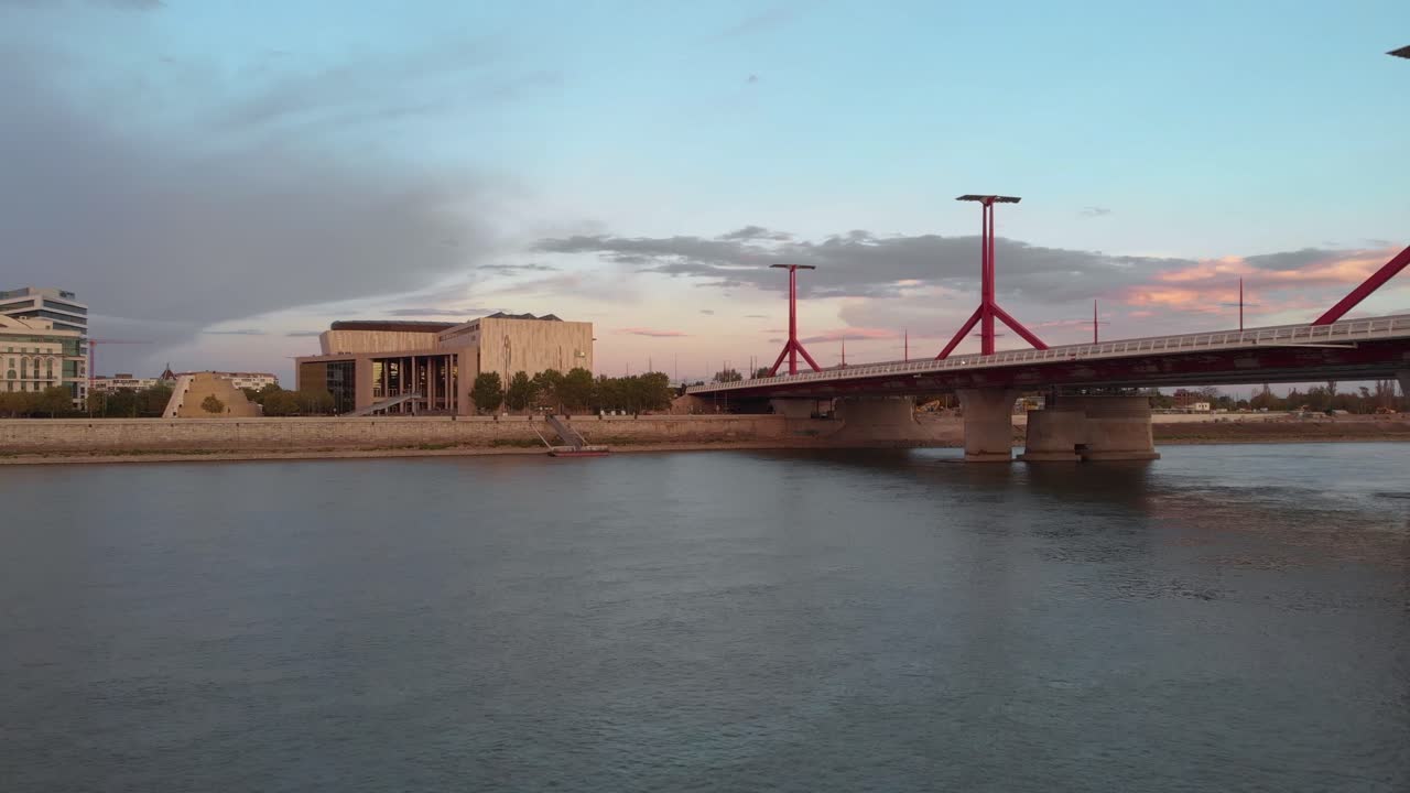 Forward drone aerial of MUPA and National Theatre over Danube, Hungary