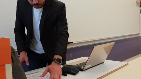 young educator with laptop in lecture hall