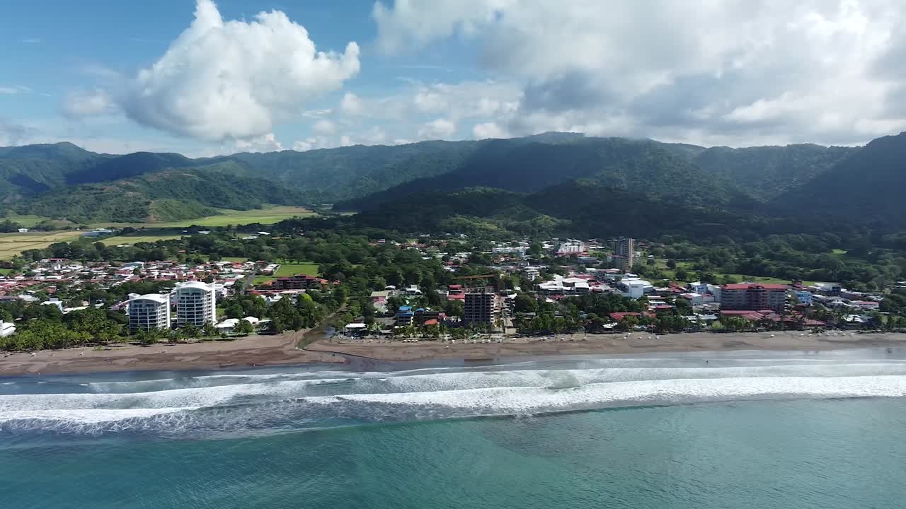 Beautiful drone shot flying over the black sand beach in Jac&oacute;, Costa Rica