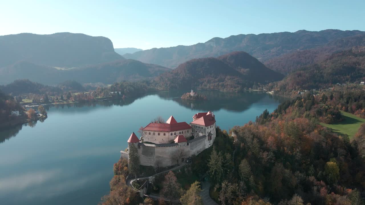 Veduta aerea del Castello di Bled con movimento da sinistra a destra, con lo splendido lago di Bled e l'isola del lago di Bled con la chiesa sullo sfondo in una mattina d'autunno in Slovenia