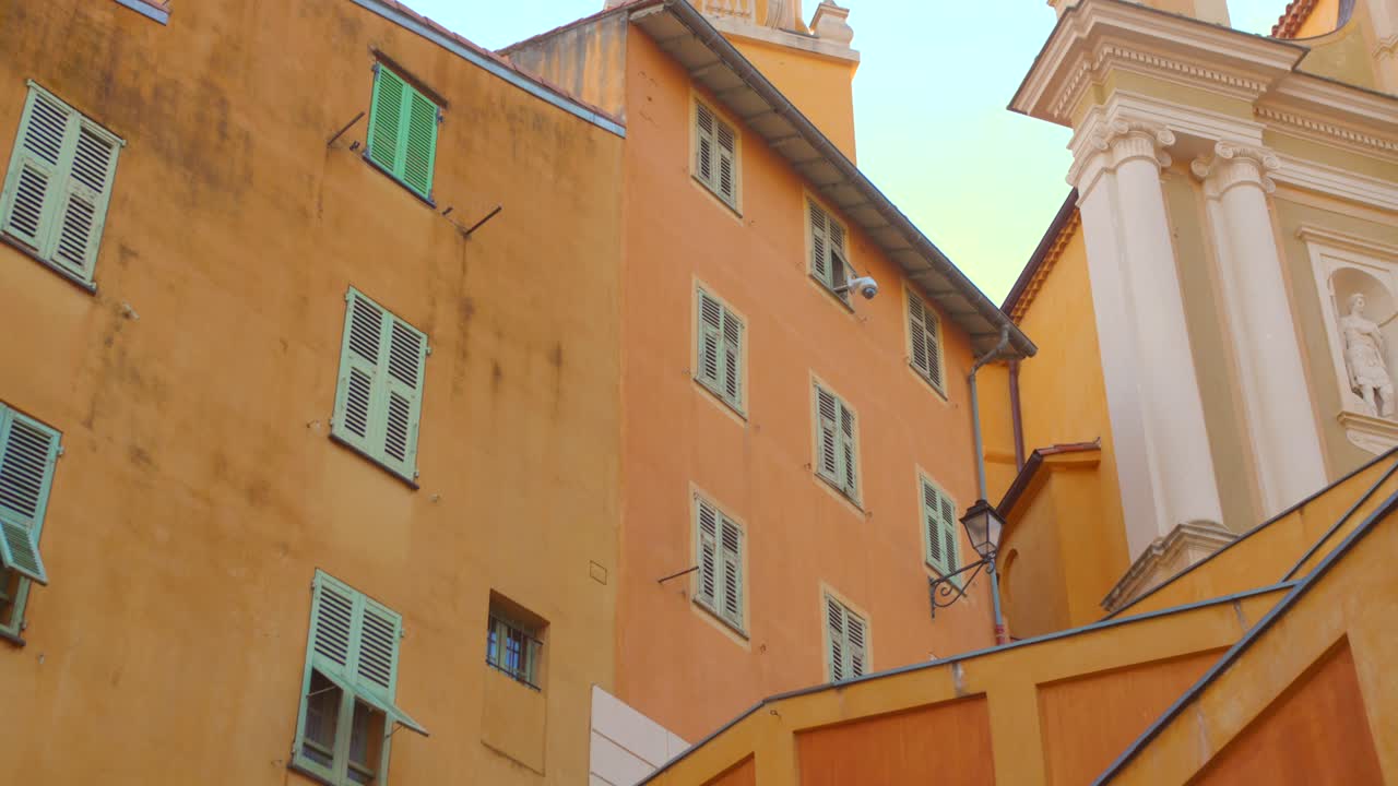 Edificios y iglesia con encanto de Menton iluminados por la luz cálida de la tarde