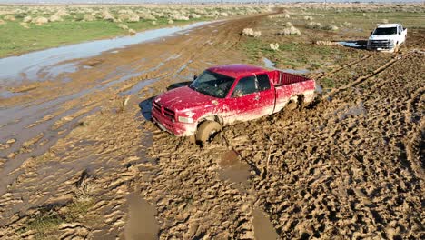 unusual torrential rains in the mojave desert leave trucks stuck in the mud - aerial orbit