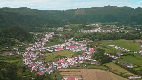 Mirador-De-Lombo-Dos-Milhos,-Furnas,-Azores,-Portugal-Con-Colinas-Verdes-Y-Casas-Con-Techo-Rojo,-Vista-Aérea