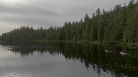 two kayakers paddling on flat calm lake