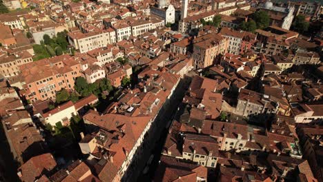 aerial drone above architecture of venice italy, red tile roof houses, sea water summer landscape and residential area, water channel and basilica