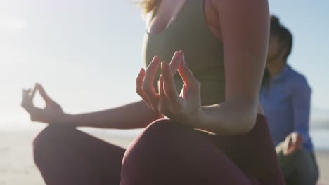 grupo de diversas amigas meditando en la playa