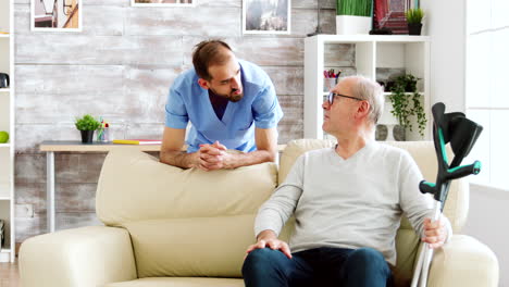 Anciano-Conversando-Con-Un-Enfermero-En-Un-Acogedor-Hogar-De-Ancianos