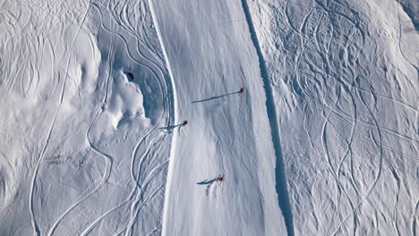 Drei-Skifahrer-Fahren-Einen-Schönen-Hang-Hinunter-Und-Wirbeln-Schnee-Auf,-Wenn-Sie-Kurven-Auf-Der-Strecke-Fahren