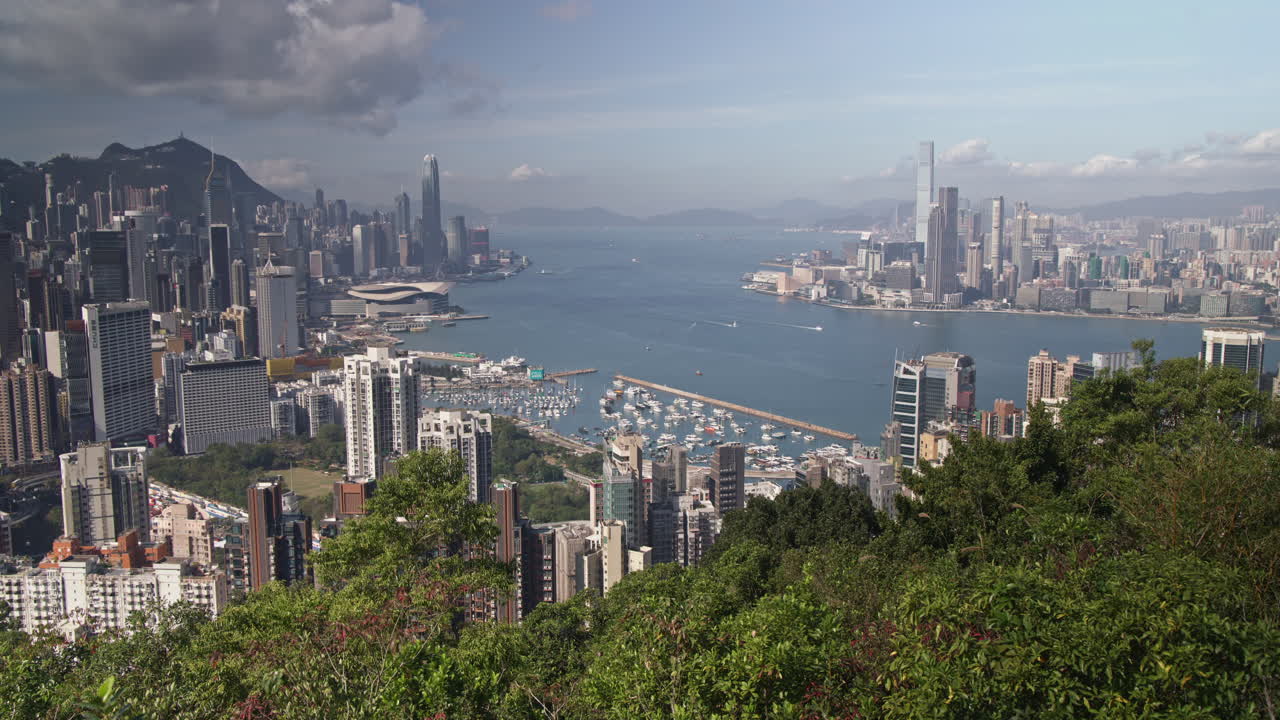 Timelapse Urban Skyline of Hong Kong Island and Kowloon with Victoria Harbour on Sunny Day
